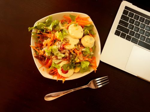 une assiète de salade près d'un ordinateur. Nous n'utilisons plus nos chèques repas pendant le télétravail