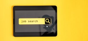 Une tablette affichant le texte "job search" sur son écran sur fond jaune.