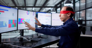 Un homme les yeux bandés devant des écrans affichant des statistiques