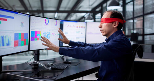 Un homme les yeux bandés devant des écrans affichant des statistiques